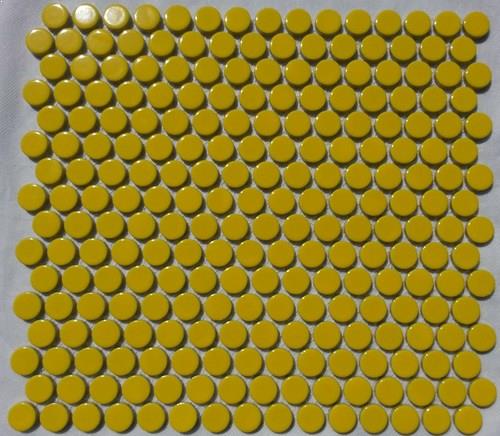 A yellow coloured round, penny mosaic porcelain tile.