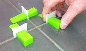 Tile leveling systems being used on floor tiles