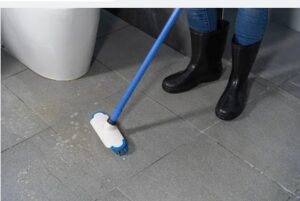 Cleaning porcelain tiles in bathroom with a brush and water