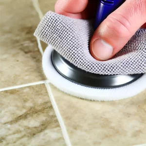 A close-up of a person polishing tiles with a microfiber cloth, revealing clean, shiny tiles.